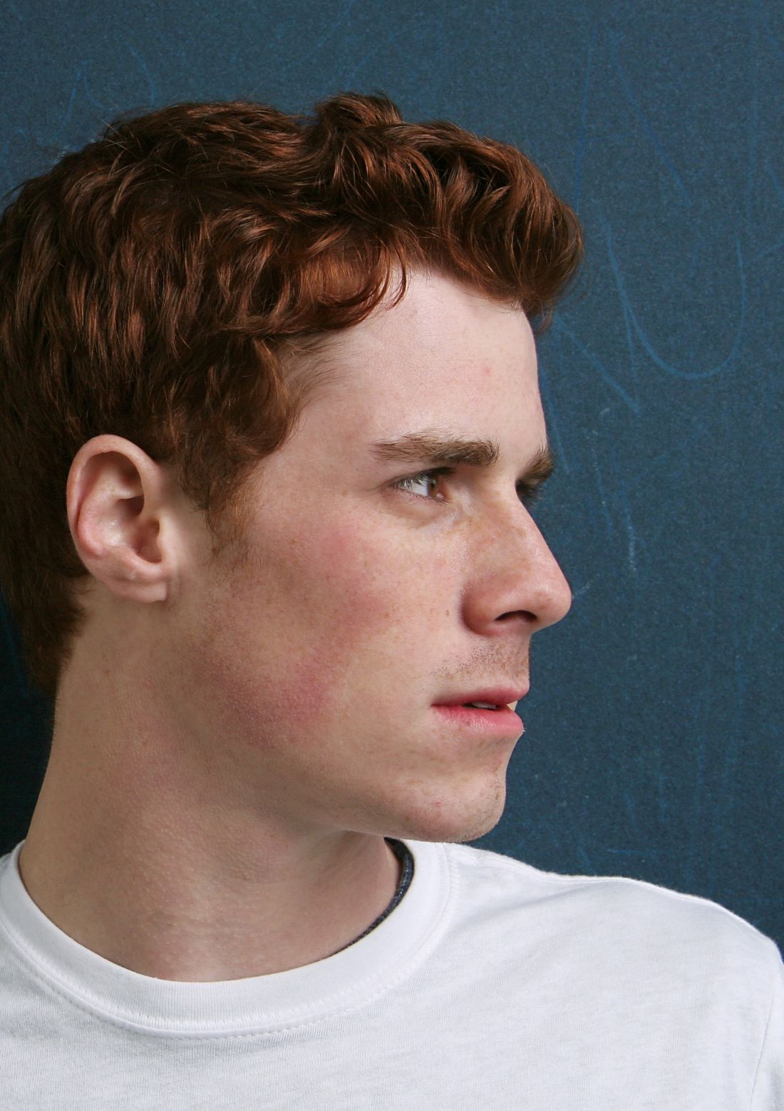 A young man in profile, looking ahead
